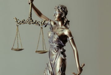 woman in gold dress holding sword figurine